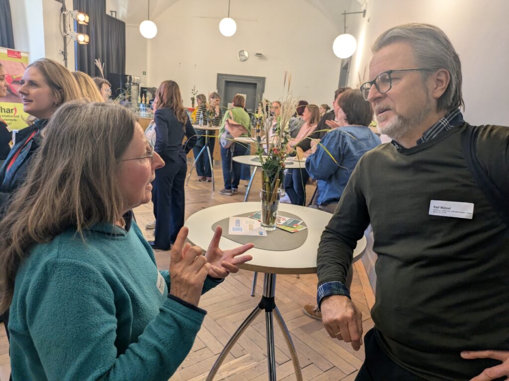 Maria Zeußel im Gespräch mit Ralf Mützel bei der Fair-Trade-Werkstatt in Nürnberg.